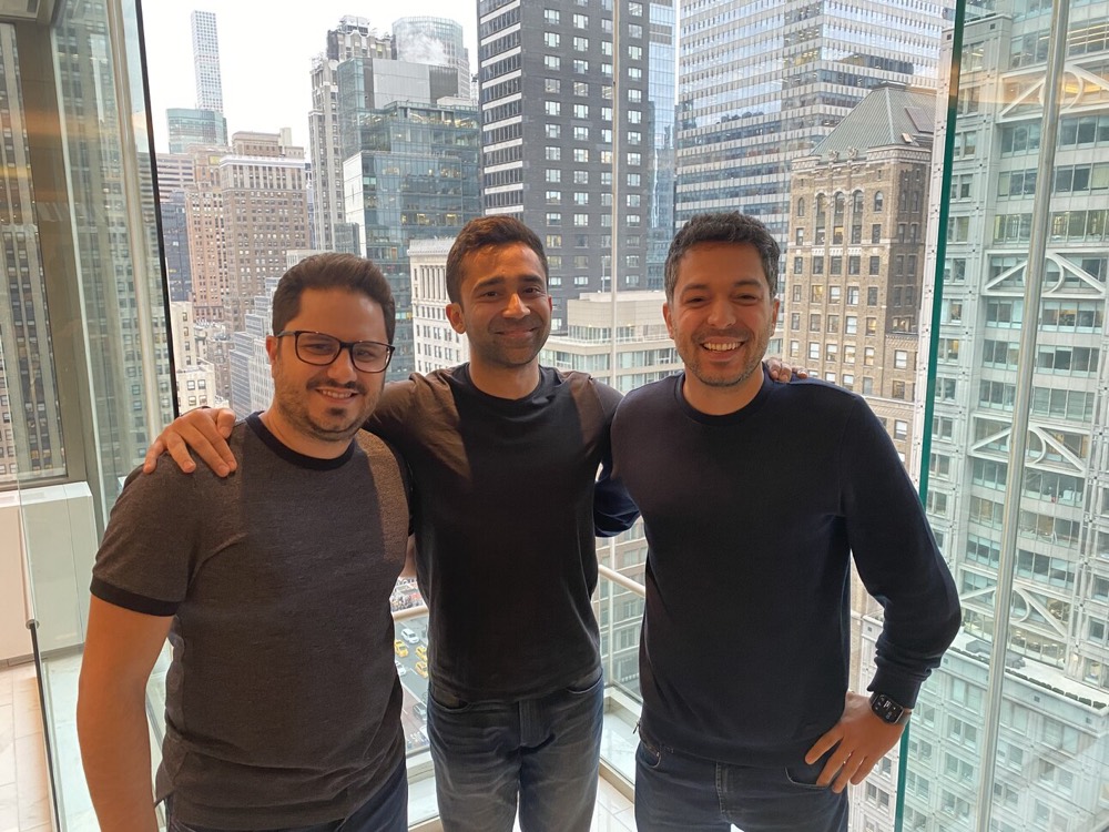 Ankur and two colleagues by a window above Midtown Manhattan